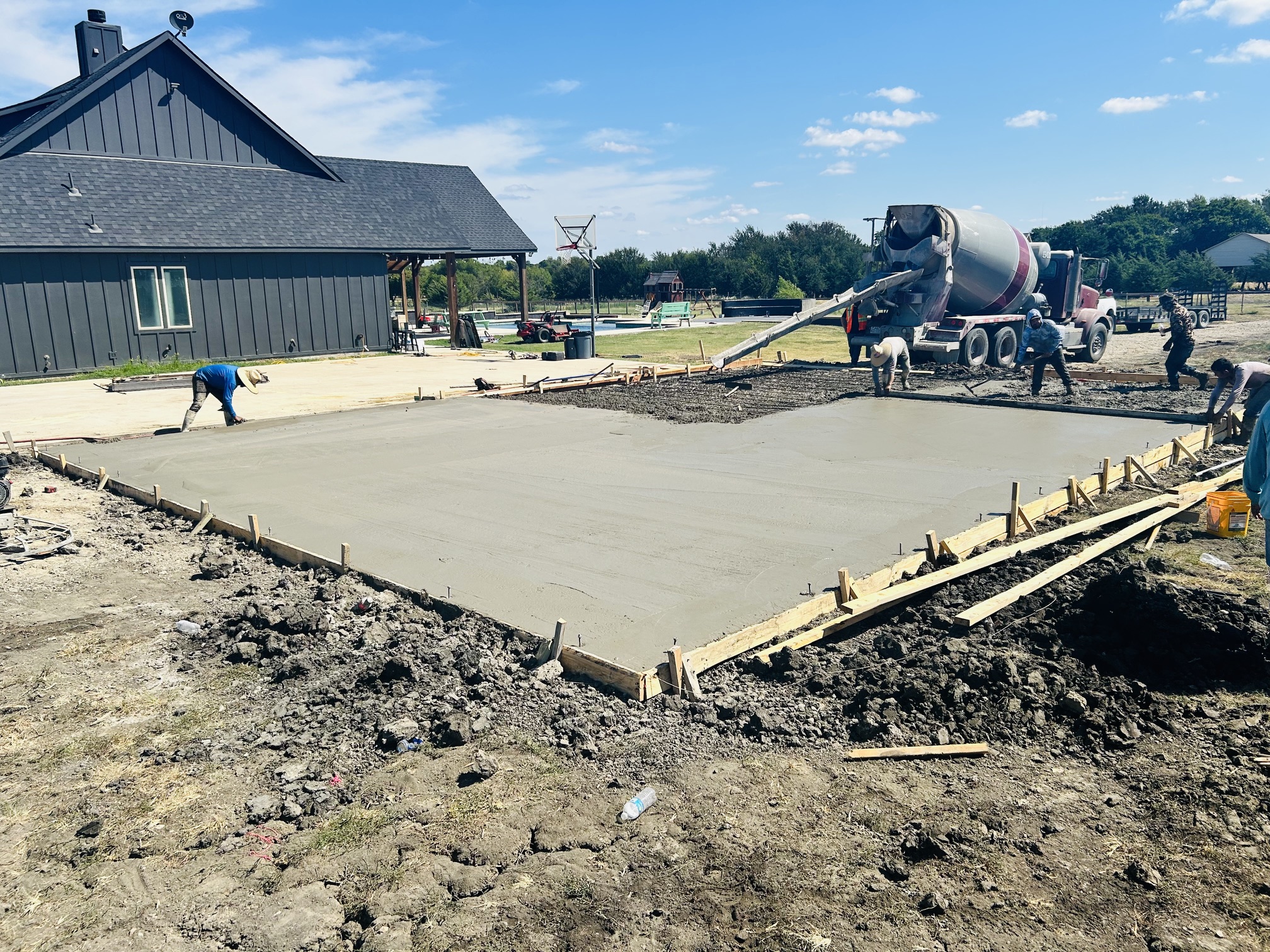 Freshly poured concrete slab foundation for new garage addition in Celeste, TX